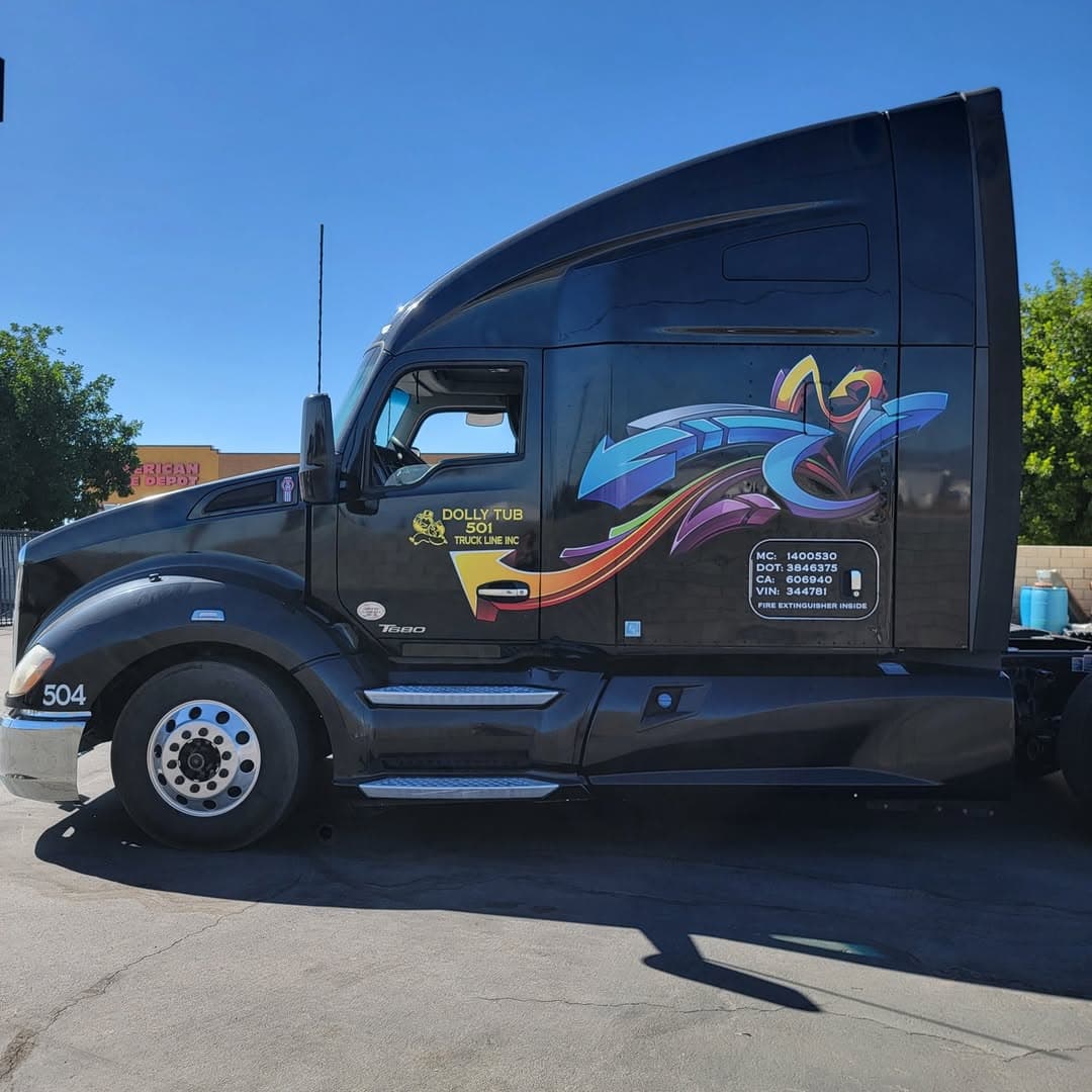 Black Kenworth T680 semi truck with colorful graffiti graphic