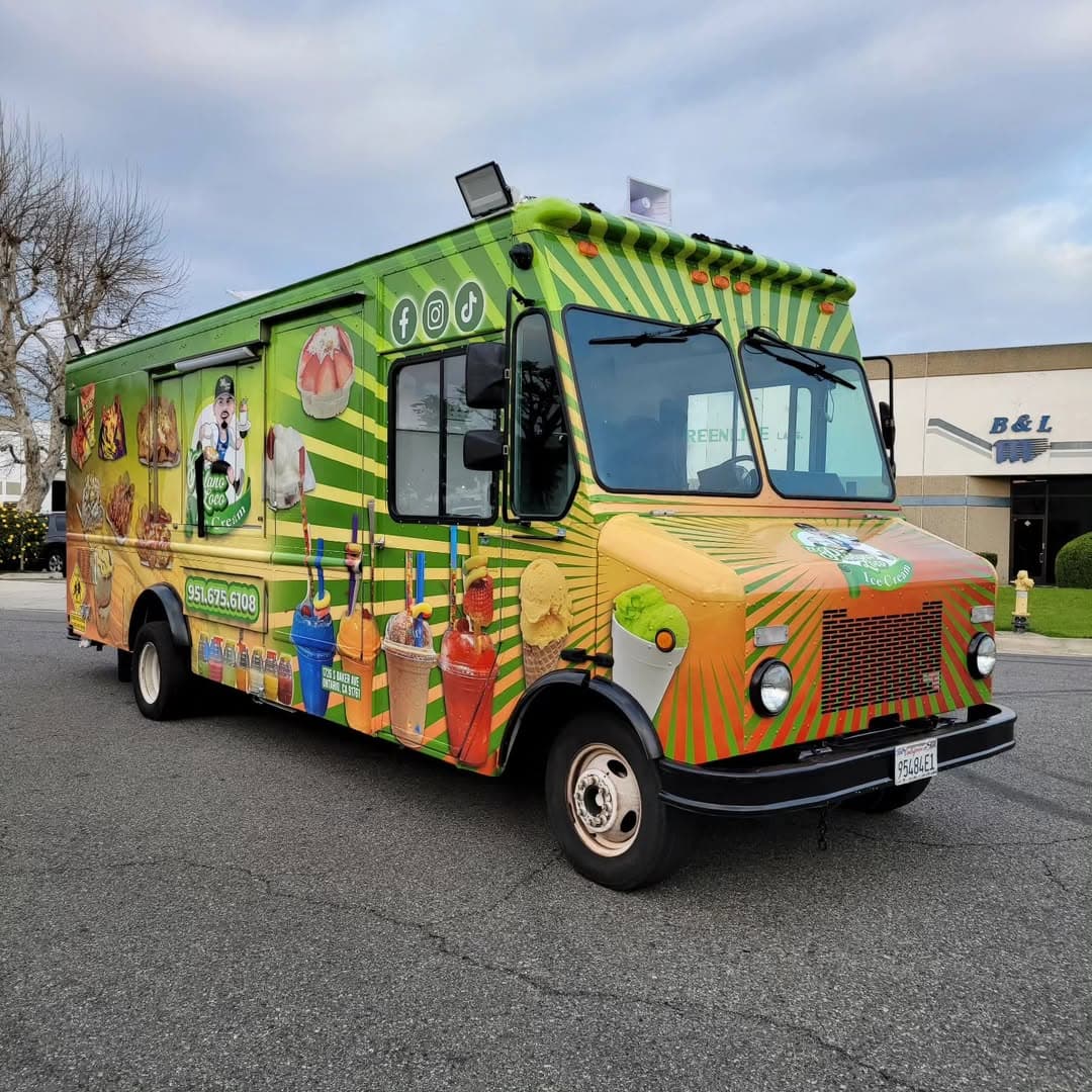 Green Mexican fruit and dessert food truck with vibrant graphics