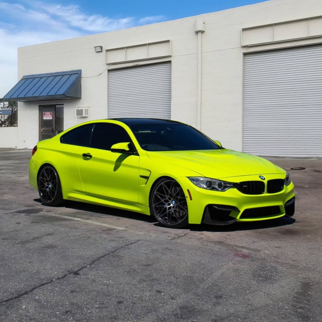 Neon lime green BMW M4 rear three-quarter view