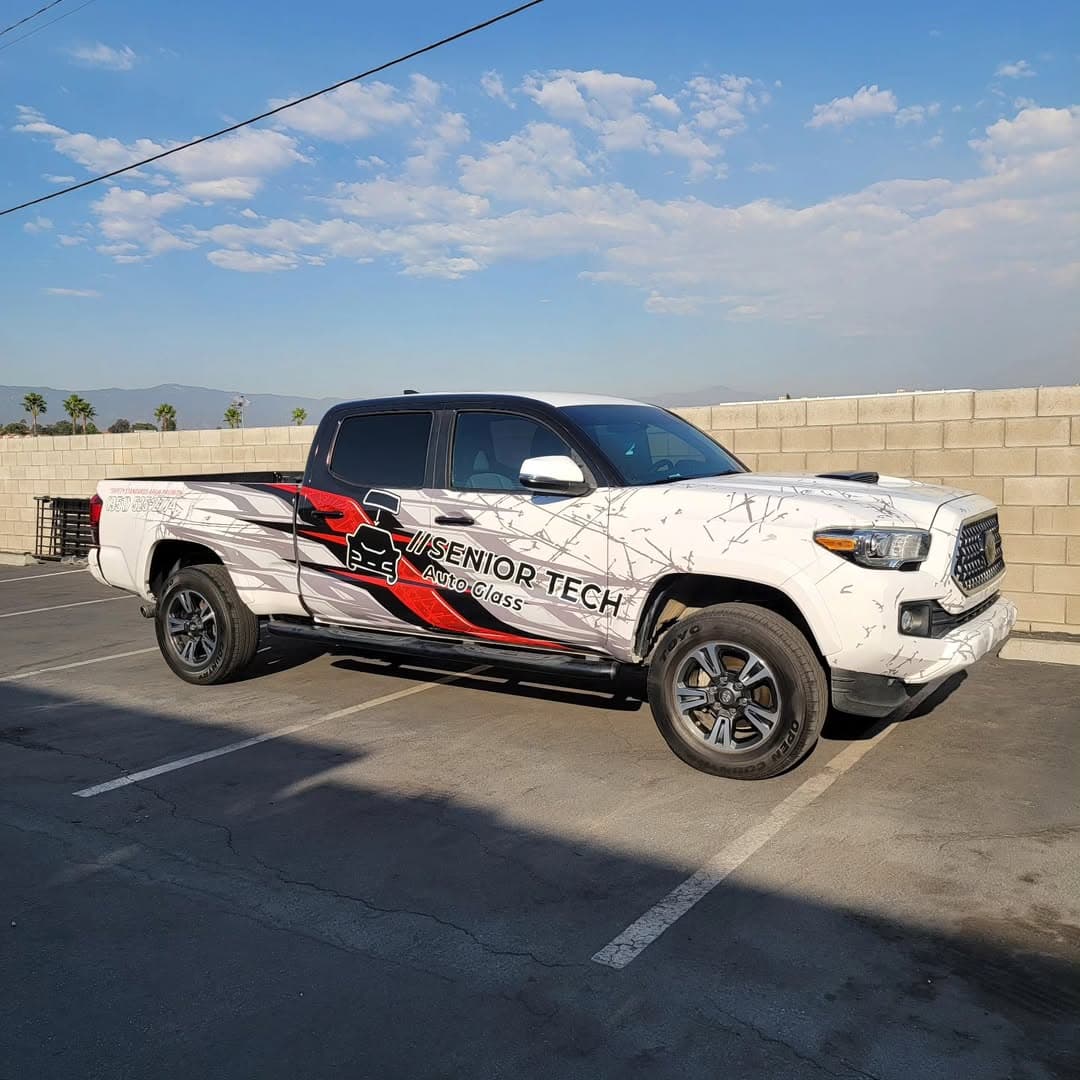 Senior Tech Auto Glass white Toyota Tacoma with red and black graphics