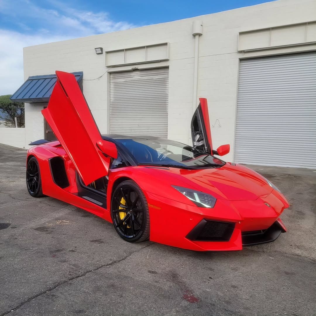 Red Lamborghini Aventador with scissor doors open, wrapped by 360 Innovation Wraps